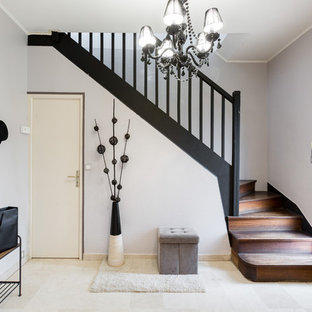 Réalisation d'un hall d'entrée bohème avec un mur gris, une porte simple, une porte blanche et un sol beige.