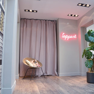 Exemple d'un grand hall d'entrée tendance avec un mur beige et un sol en bois clair.