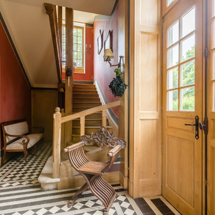 Inspiration pour un hall d'entrée victorien avec un mur rouge, une porte double, une porte en verre et un sol multicolore.