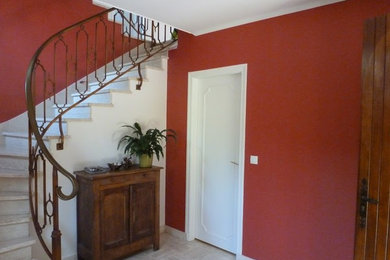 Idée de décoration pour un hall d'entrée design de taille moyenne avec un mur rouge, une porte double, une porte en bois brun et un sol beige.