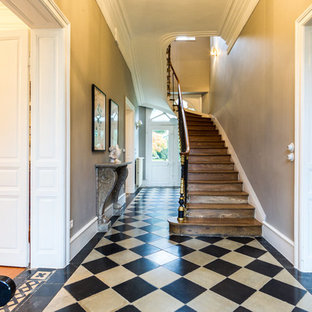 Idée de décoration pour une entrée tradition avec un couloir, un mur beige, un sol multicolore, une porte double et une porte blanche.