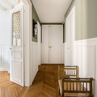 Inspiration pour une entrée traditionnelle avec un couloir, un mur vert, un sol en bois brun, une porte simple, une porte blanche et un sol marron.