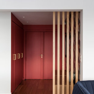 Idee per un ingresso minimal di medie dimensioni con pareti rosse, parquet chiaro, una porta a due ante e una porta rossa
