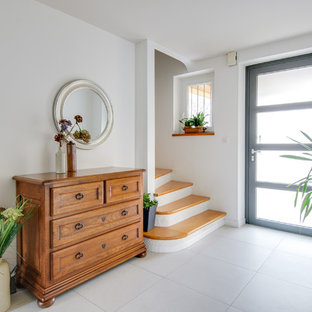 Idée de décoration pour un hall d'entrée design de taille moyenne avec un mur blanc, un sol en carrelage de céramique, une porte simple, une porte grise et un sol beige.