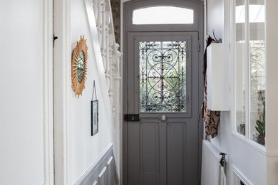 Diseño de hall actual pequeño con paredes blancas, puerta simple, puerta gris y suelo gris