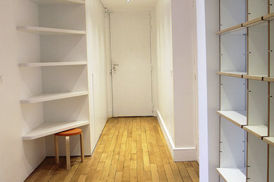 Cette photo montre un très grand hall d'entrée tendance avec un mur blanc, parquet clair et une porte simple.