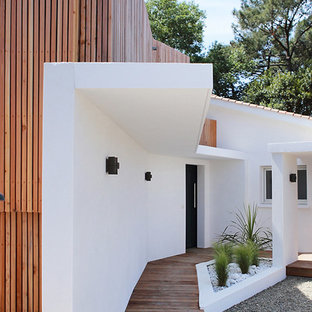 Idées déco pour une porte d'entrée contemporaine avec un mur blanc, un sol en bois brun, une porte simple, une porte noire et un sol marron.