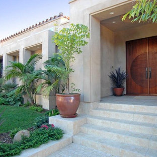 Immagine di una grande porta d'ingresso mediterranea con una porta a due ante, una porta in legno scuro, pareti beige, pavimento in pietra calcarea e pavimento marrone