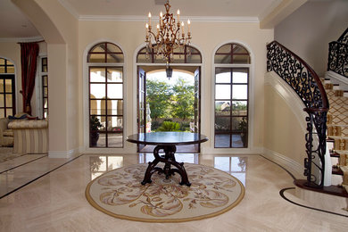 Entryway - large traditional marble floor entryway idea in Phoenix with beige walls and a glass front door