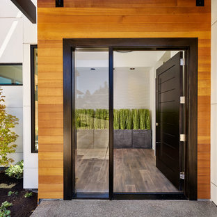 Large trendy medium tone wood floor entryway photo in Portland with white walls and a black front door