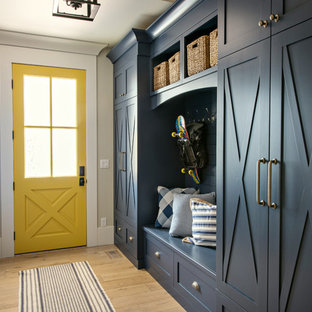 Ispirazione per un ingresso con anticamera classico con pareti beige, parquet chiaro, una porta gialla e pavimento beige