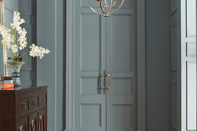 Inspiration for a timeless medium tone wood floor entryway remodel in Other with blue walls