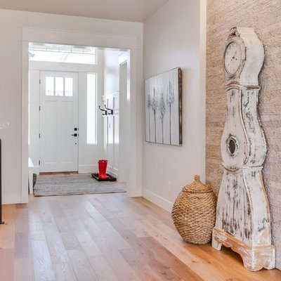 Entryway - mid-sized transitional medium tone wood floor and brown floor entryway idea in Boise with beige walls and a white front door