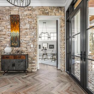 Geräumiger Landhausstil Eingang mit Foyer, weißer Wandfarbe, hellem Holzboden, Doppeltür, schwarzer Tür und buntem Boden in Indianapolis
