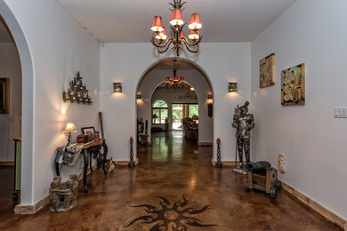 Example of a large arts and crafts concrete floor and brown floor foyer design in Other with white walls and a dark wood front door
