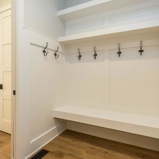 Imagen de vestíbulo posterior tradicional renovado, de tamaño medio, con paredes grises, suelo de madera clara, puerta simple y puerta blanca