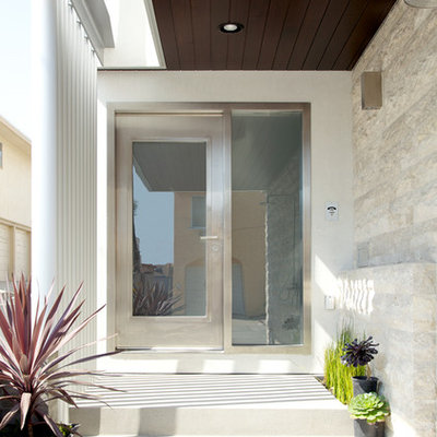 Example of a trendy entryway design in Los Angeles with a glass front door