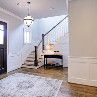 Kleiner Rustikaler Eingang mit Foyer, grauer Wandfarbe, braunem Holzboden, Einzeltür, brauner Tür, braunem Boden, vertäfelten Wänden und Treppe in Houston