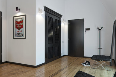 他の地域にあるコンテンポラリースタイルのおしゃれな玄関ホール (白い壁、無垢フローリング、濃色木目調のドア) の写真