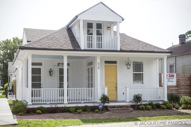 Large classic front door in New Orleans with white walls, painted wood flooring, a single front door and a yellow front door.