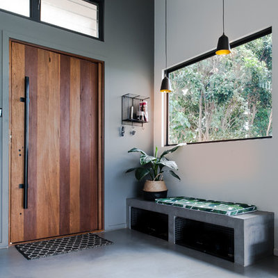 Entryway - contemporary concrete floor and gray floor entryway idea in Gold Coast - Tweed with white walls and a medium wood front door