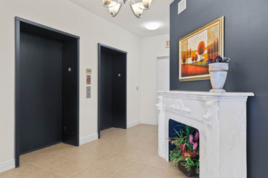他の地域にある高級な中くらいなトラディショナルスタイルのおしゃれな玄関ロビー (白い壁、セラミックタイルの床、白いドア、マルチカラーの床、三角天井) の写真