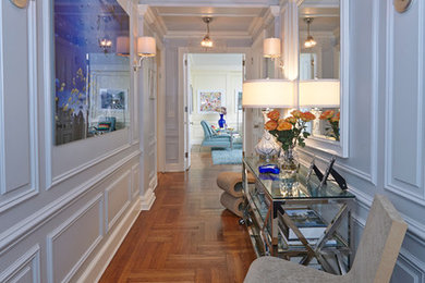 Example of a large minimalist medium tone wood floor and brown floor entry hall design in New York with blue walls