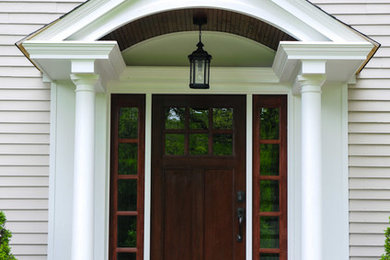 Diseño de puerta principal tradicional con paredes beige, puerta simple y puerta de madera oscura