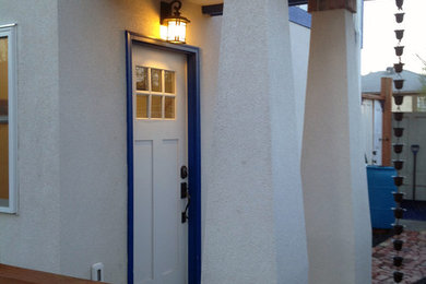 デンバーにあるお手頃価格の小さなエクレクティックスタイルのおしゃれな玄関ドア (白い壁、レンガの床、白いドア) の写真