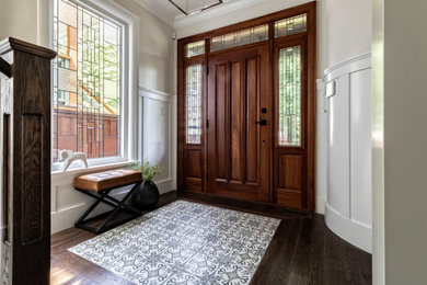 バンクーバーにある高級な中くらいなトラディショナルスタイルのおしゃれな玄関ドア (ベージュの壁、濃色無垢フローリング、茶色いドア、茶色い床、羽目板の壁) の写真