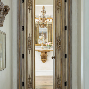 Medium tone wood floor and brown floor entryway photo in Little Rock with white walls