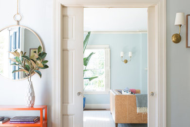 Foto de entrada ecléctica con paredes grises, suelo de madera en tonos medios, puerta simple y puerta blanca