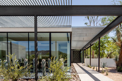 Inspiration for a modern pivot front door remodel in Phoenix with white walls and a glass front door