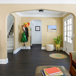 Entryway - mid-sized traditional dark wood floor entryway idea in Minneapolis with yellow walls and a white front door