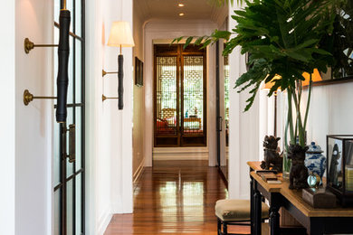 Exemple d'une grande entrée chic avec un couloir, un mur blanc, un sol en bois brun, une porte simple, une porte bleue et un sol marron.