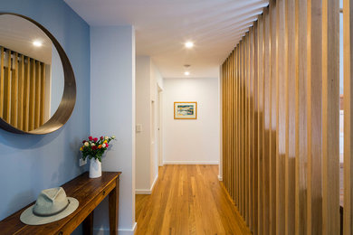 Ispirazione per un ingresso o corridoio minimalista con pavimento in legno massello medio