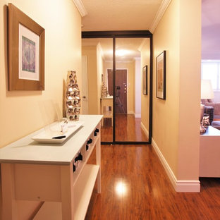 Inspiration pour un petit hall d'entrée traditionnel avec un mur beige, un sol en vinyl, une porte simple et une porte en bois brun.