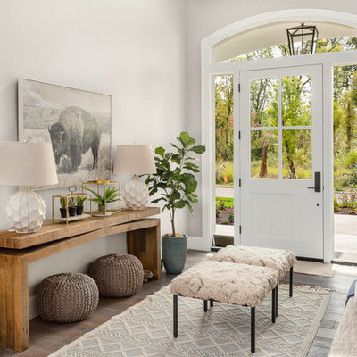 Transitional medium tone wood floor and brown floor single front door photo in Portland with beige walls and a white front door