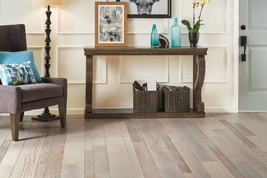 Mid-sized elegant medium tone wood floor and brown floor entryway photo in New York with white walls and a gray front door