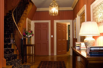 Mid-sized transitional light wood floor entryway photo in New York with multicolored walls and a red front door