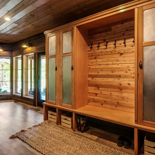 Idée de décoration pour une entrée chalet de taille moyenne avec un vestiaire, un mur marron, un sol en vinyl, une porte simple, une porte en verre et un sol marron.