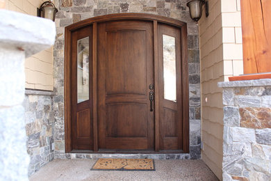 Immagine di una grande porta d'ingresso minimalista con una porta singola e una porta in legno scuro