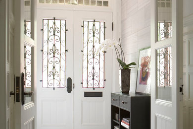 Example of a large classic marble floor and white floor entryway design in Boston with white walls and a white front door