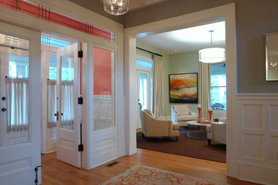 Inspiration for a large transitional medium tone wood floor entryway remodel in Baltimore with orange walls and a white front door
