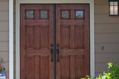 Ejemplo de entrada tradicional con puerta doble y puerta de madera oscura
