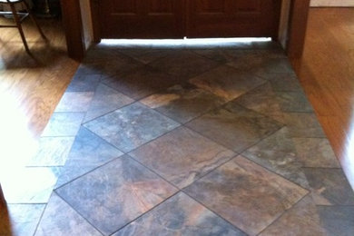 Entryway - small traditional porcelain tile entryway idea in Orlando with white walls and a dark wood front door
