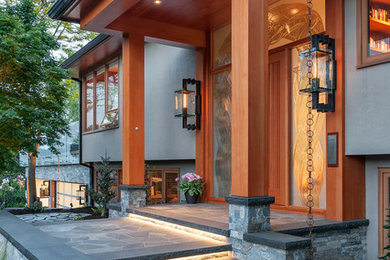 Imagen de puerta principal actual de tamaño medio con paredes beige, suelo de granito y puerta de madera en tonos medios
