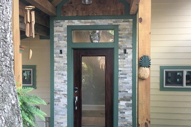 Small arts and crafts concrete floor entryway photo in Orlando with multicolored walls and a dark wood front door