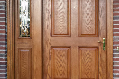 Modelo de puerta principal tradicional de tamaño medio con puerta simple y puerta de madera oscura