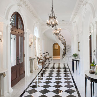Inspiration pour un grand hall d'entrée traditionnel avec un mur blanc, une porte double, une porte en bois foncé, un sol en marbre et un sol multicolore.